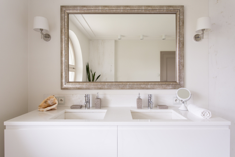 Framed mirror above a double-sink vanity.