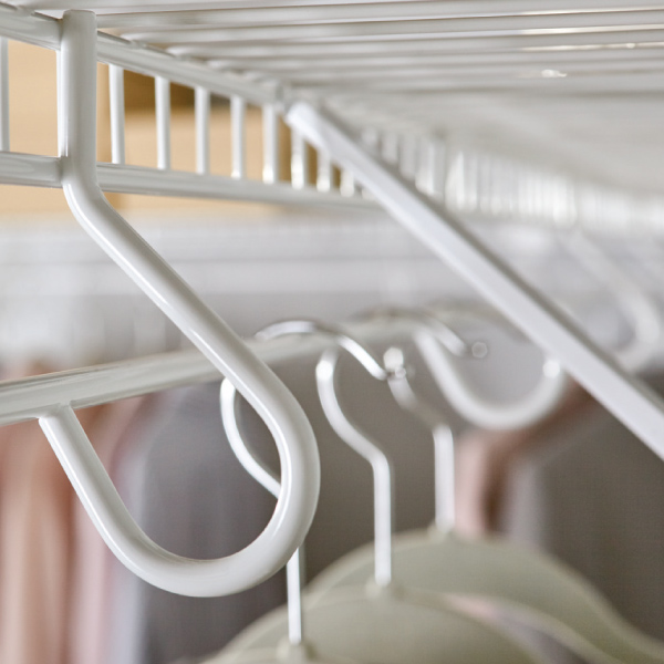 Close view of hangars on wire closet shelving.