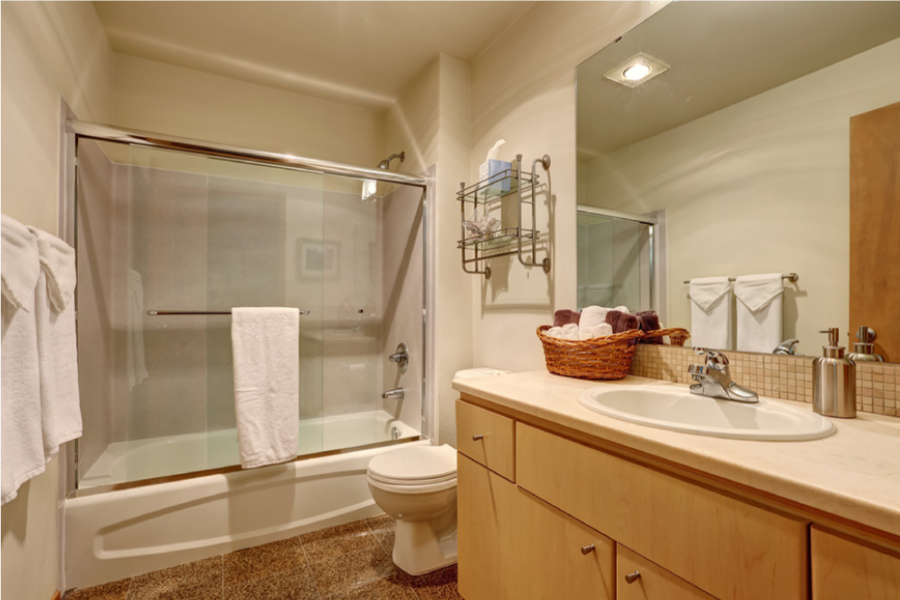 Sliding Shower Door in a small bathroom with wood accents.