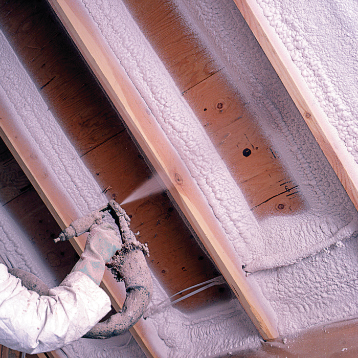 Spray foam insulation being installed in attic roof joists.