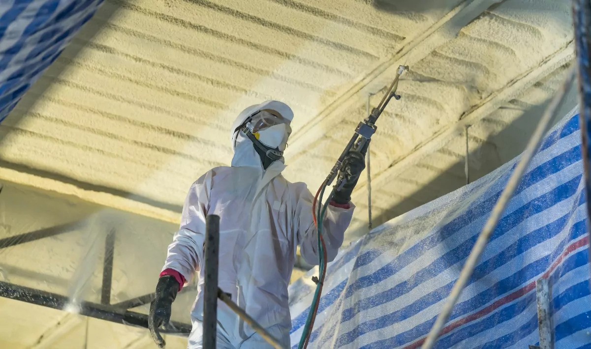 Spray foam installer working on a ceiling.