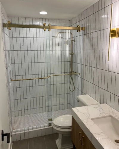 Custom glass sliding shower door installation, in customer's elegant bathroom.