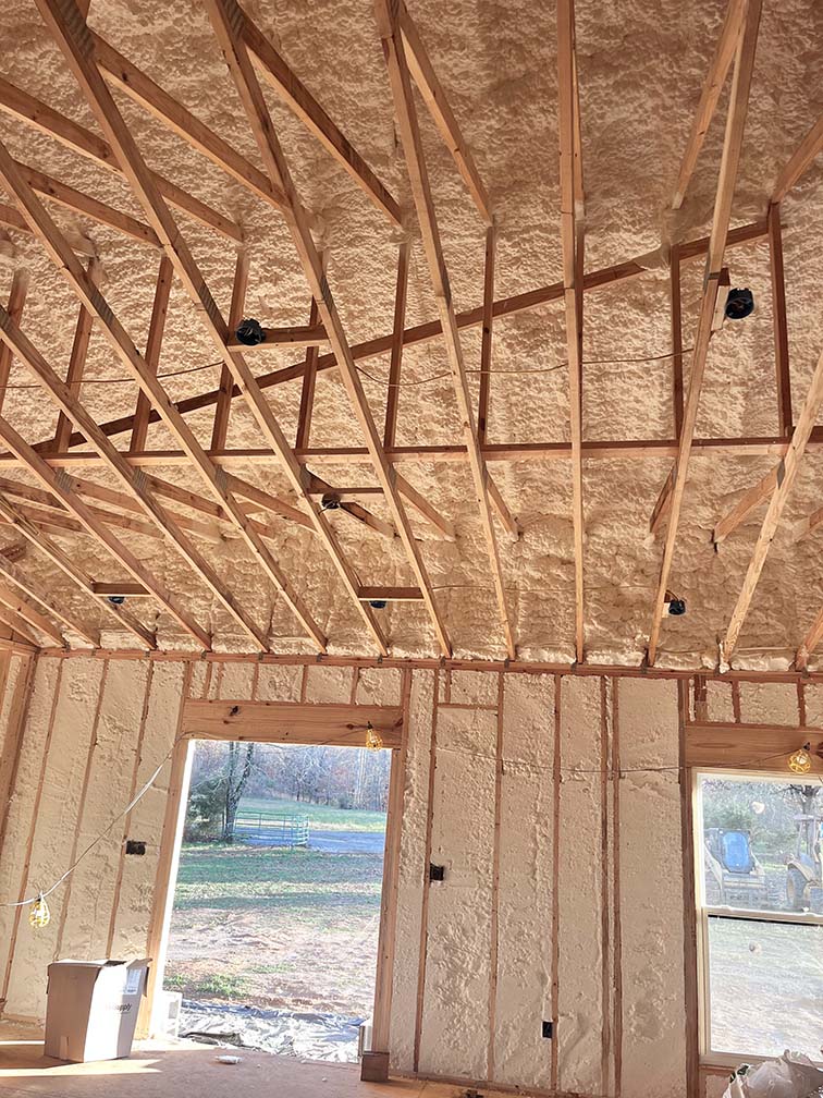 Spray foam insulation installation in new home's walls and ceiling.
